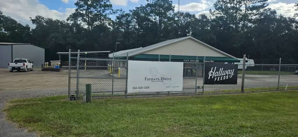 The Farmers Direct Hay and Feed gate sign and Hallway Feeds banner at the Williston, FL store